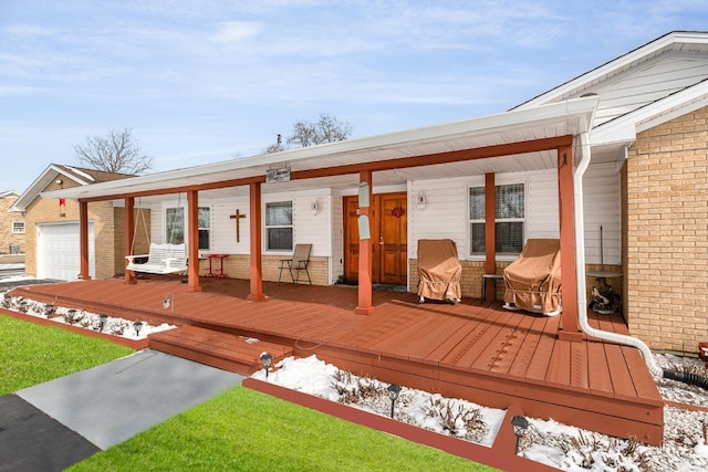 wooden deck featuring a porch and a garage