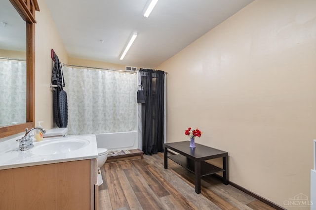 full bath with wood finished floors, vanity, vaulted ceiling, and toilet