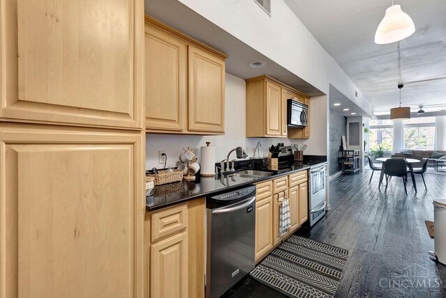 kitchen with stainless steel appliances, visible vents, light brown cabinetry, dark wood-type flooring, and a sink