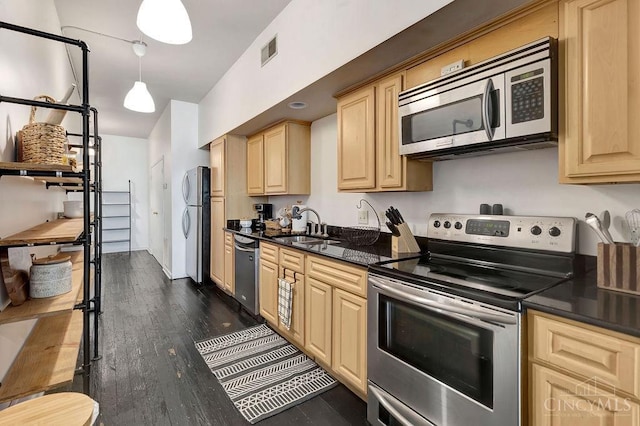 kitchen featuring dark wood finished floors, dark countertops, appliances with stainless steel finishes, light brown cabinetry, and a sink