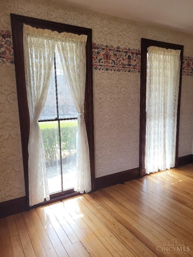 1144 Round Bottom Rd, Union Twp, OH 45150 - unfurnished dining area featuring hardwood / wood-style floors, wallpapered walls, and baseboards