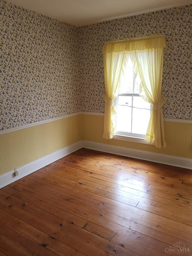 1144 Round Bottom Rd, Union Twp, OH 45150 - spare room with wallpapered walls, a wainscoted wall, baseboards, and wood-type flooring