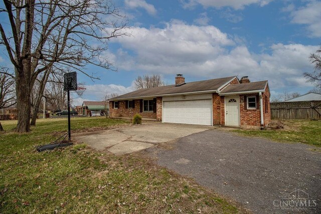 single story home with an attached garage, brick siding, driveway, and a chimney