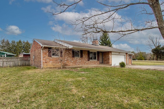 view of front of house with concrete driveway, fence, brick siding, and a front lawn