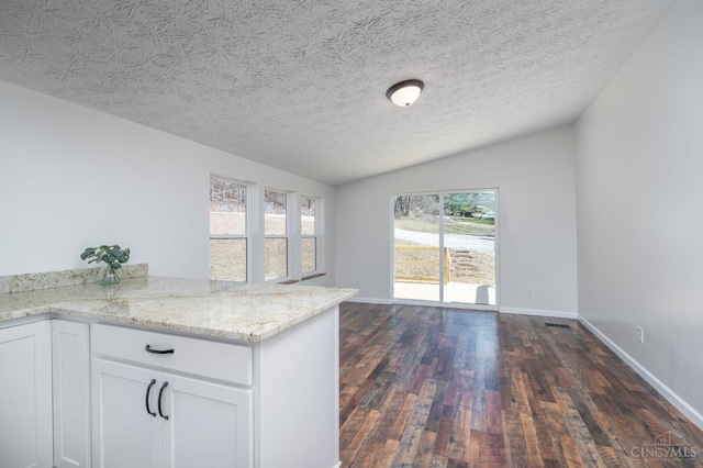 5103 Washburn Rd, Brushcreek Twp, OH 45133 - kitchen with lofted ceiling, dark wood finished floors, light stone countertops, white cabinets, and baseboards