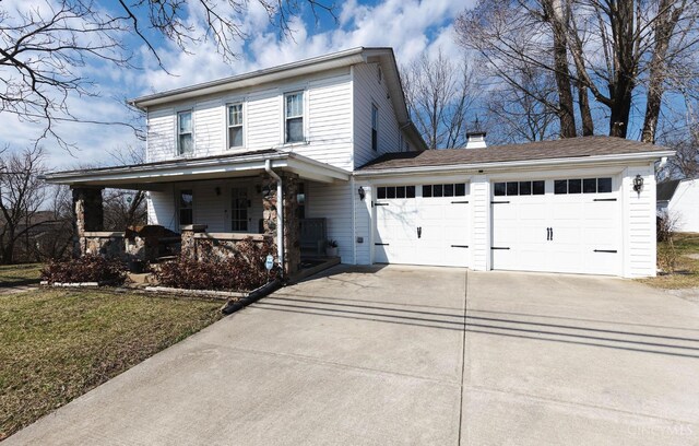 view of front of property with covered porch, driveway, a chimney, and a garage