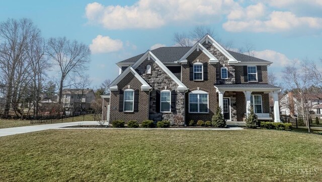 view of front of house with brick siding, stone siding, and a front yard