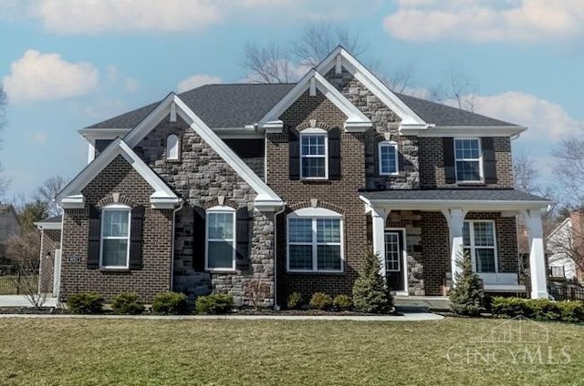 view of front facade featuring stone siding, brick siding, and a front lawn