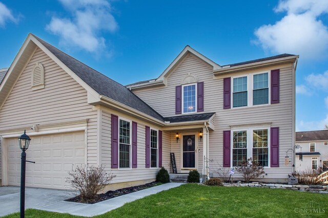 traditional-style house featuring an attached garage, concrete driveway, and a front yard