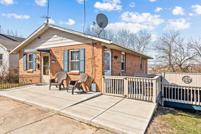 back of property featuring brick siding and fence