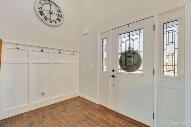 entrance foyer with dark wood finished floors and a decorative wall