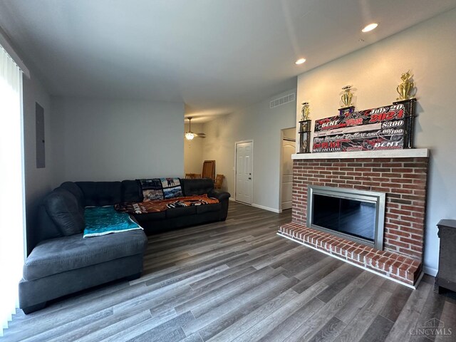 living room with a fireplace, recessed lighting, wood finished floors, and visible vents