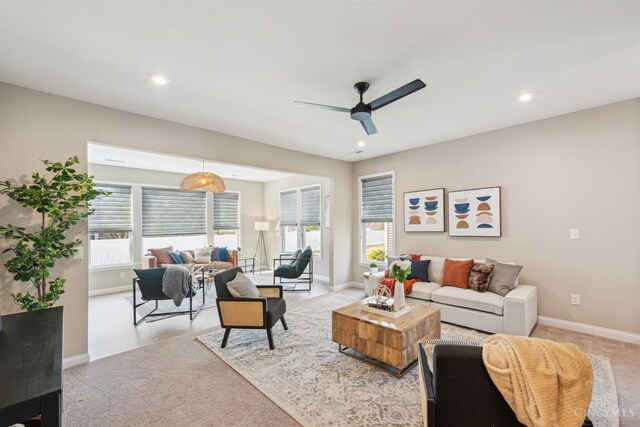 living area featuring recessed lighting, baseboards, light colored carpet, and ceiling fan