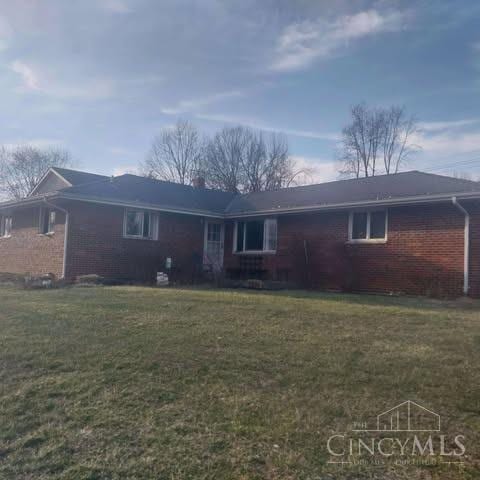 rear view of house with a yard and brick siding