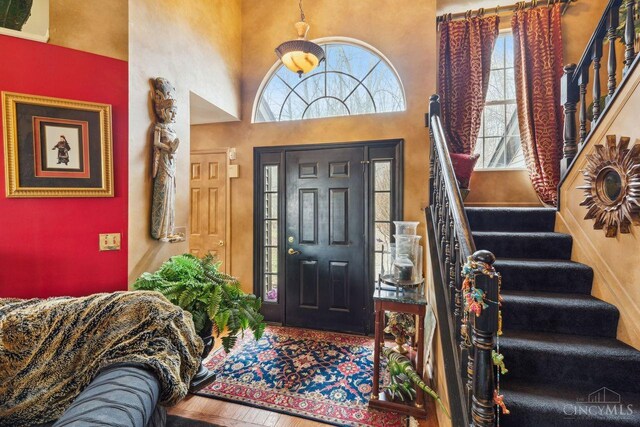 foyer featuring stairway and a towering ceiling