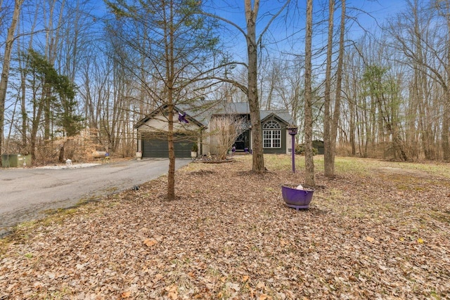 ranch-style house featuring aphalt driveway and a garage