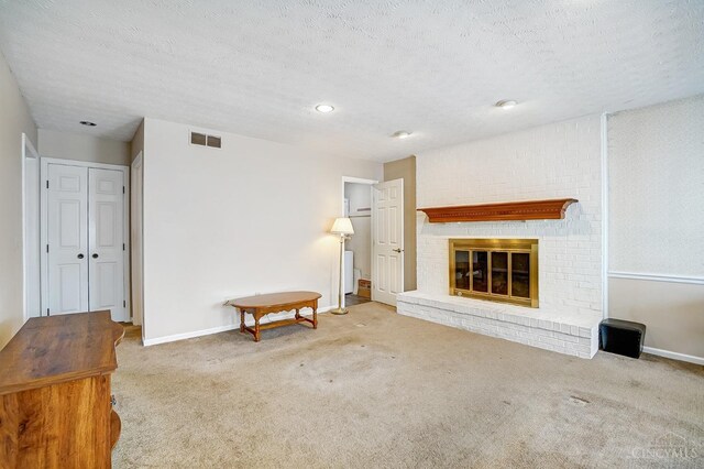 carpeted living room with visible vents, baseboards, a textured ceiling, and a brick fireplace