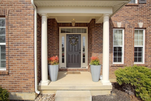 entrance to property featuring brick siding