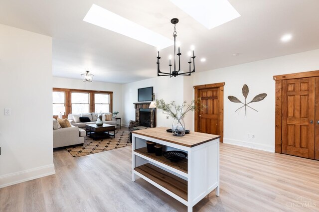 6114 Reily Millville Rd, Reily Twp, OH 45056 - kitchen featuring a skylight, light wood-style floors, an inviting chandelier, white cabinets, and open shelves
