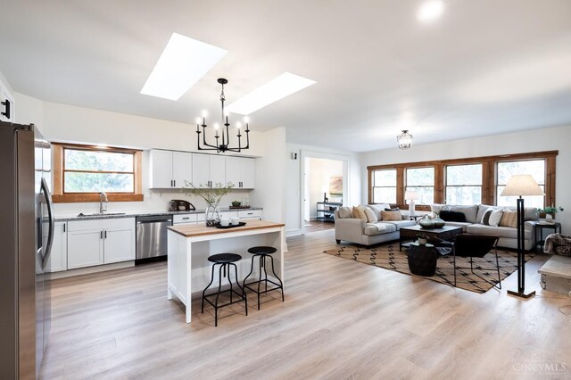 6114 Reily Millville Rd, Reily Twp, OH 45056 - kitchen with a notable chandelier, a sink, open floor plan, stainless steel appliances, and a skylight