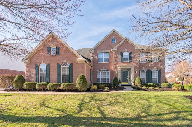 view of front of property featuring brick siding and a front yard