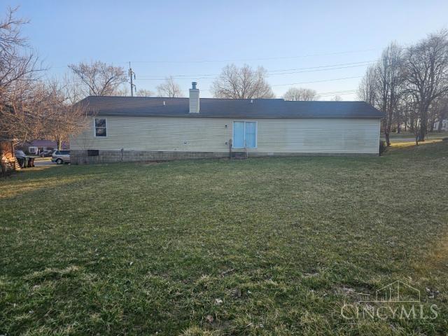 back of property featuring a lawn