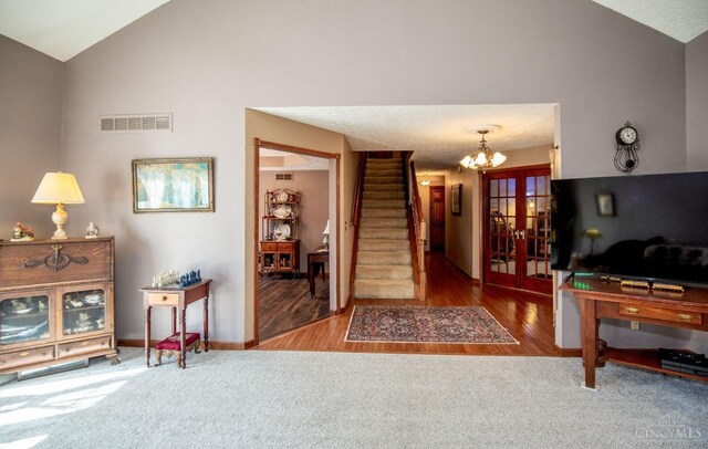 343 Whiteoak Dr, Wilmington, OH 45177 - living area with lofted ceiling, stairs, french doors, a chandelier, and wood finished floors
