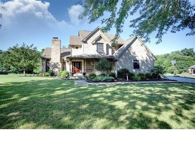 343 Whiteoak Dr, Wilmington, OH 45177 - view of front of property with a porch, stone siding, a front lawn, and a chimney