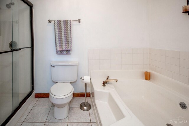 343 Whiteoak Dr, Wilmington, OH 45177 - full bathroom featuring toilet, a garden tub, a stall shower, tile patterned floors, and baseboards