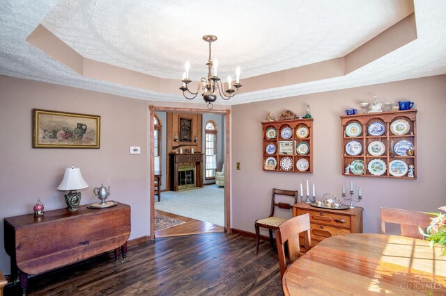 343 Whiteoak Dr, Wilmington, OH 45177 - dining area featuring a chandelier, a tray ceiling, dark wood-type flooring, baseboards, and a textured ceiling