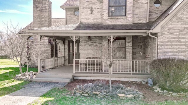 343 Whiteoak Dr, Wilmington, OH 45177 - doorway to property with covered porch, brick siding, a chimney, and a shingled roof