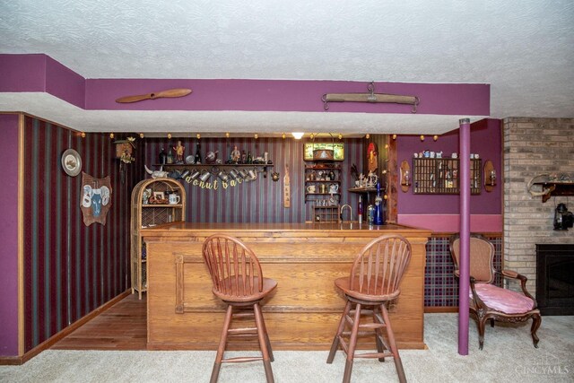 343 Whiteoak Dr, Wilmington, OH 45177 - indoor bar featuring a textured ceiling, carpet flooring, and a brick fireplace