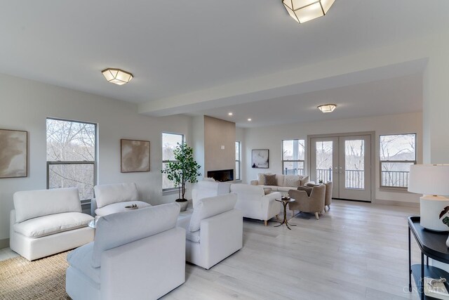 living room with french doors and light wood-style floors