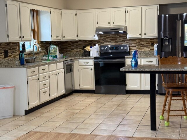 kitchen featuring black appliances, under cabinet range hood, backsplash, and white cabinets