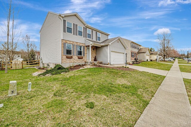 view of front of house featuring driveway, a front yard, fence, and brick siding
