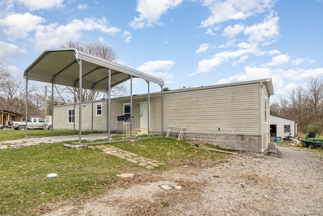 rear view of house with a detached carport, entry steps, and driveway