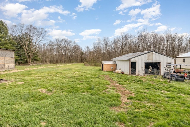 view of green lawn with an outbuilding, an outdoor structure, and a garage