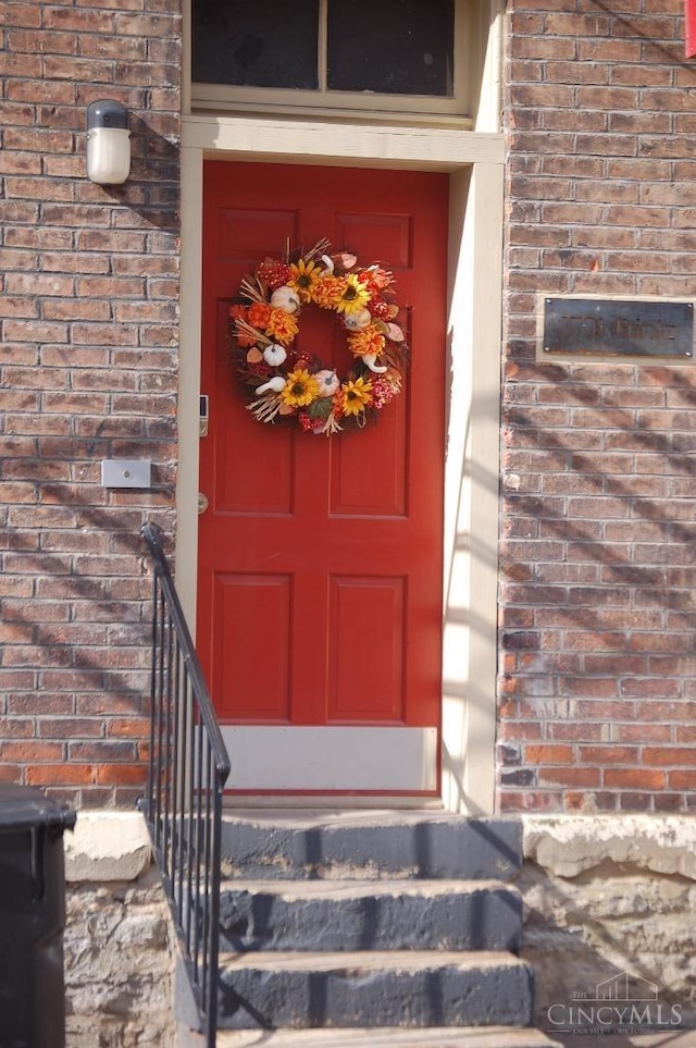 view of exterior entry featuring brick siding