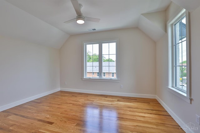 additional living space featuring plenty of natural light, lofted ceiling, and light wood-style flooring