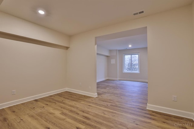 unfurnished room featuring wood finished floors, baseboards, and recessed lighting