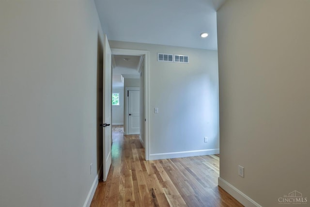 corridor featuring baseboards, light wood-type flooring, and recessed lighting