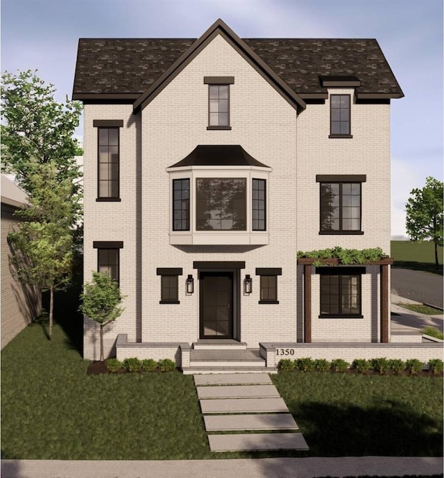 view of front of home with brick siding and a front lawn