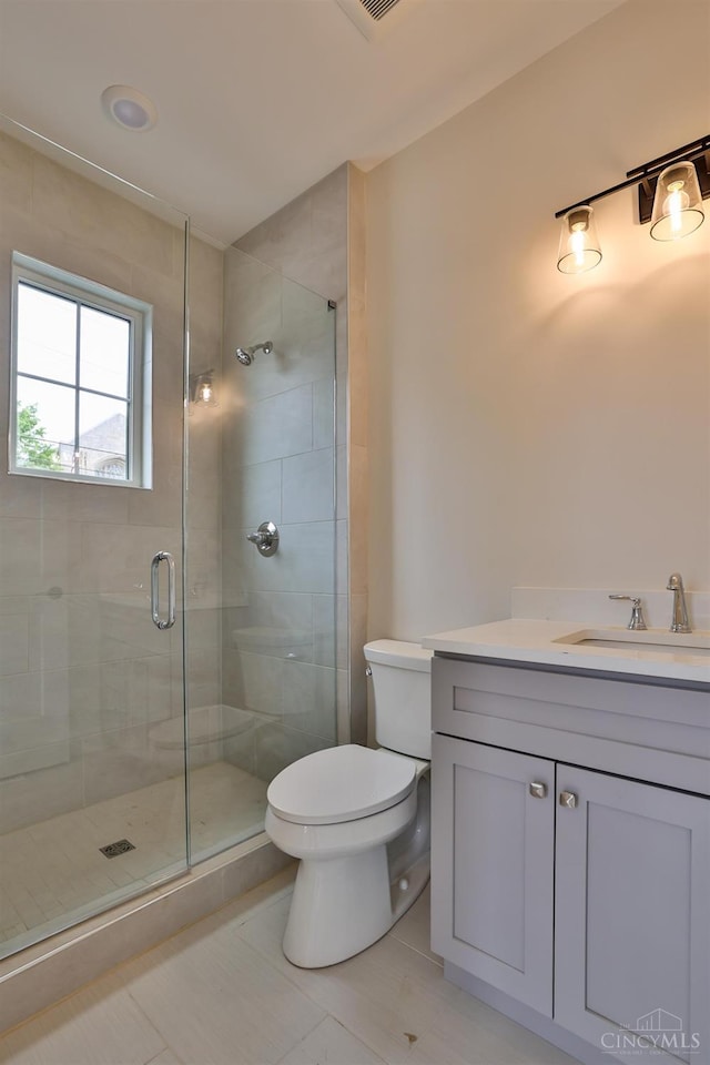 full bath with a shower stall, vanity, toilet, and tile patterned flooring