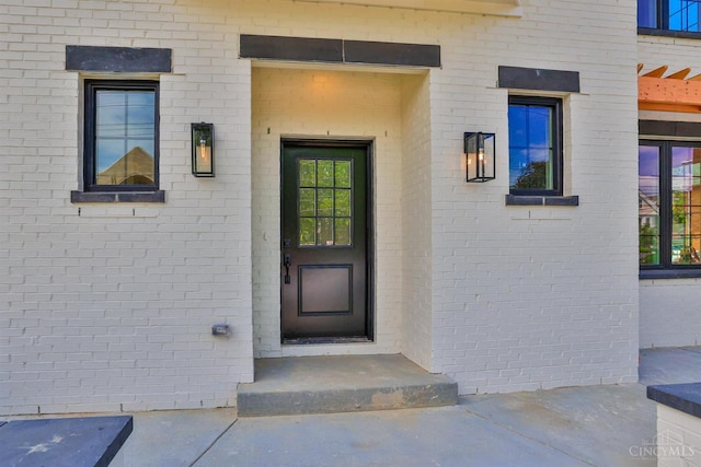 view of exterior entry with brick siding