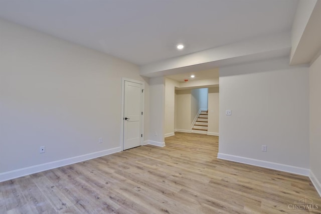 empty room featuring stairway, recessed lighting, baseboards, and light wood-type flooring