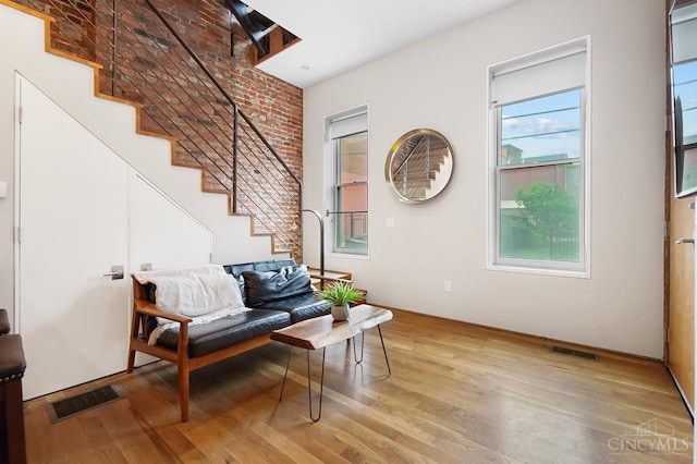 sitting room featuring light wood-style floors, stairway, and visible vents
