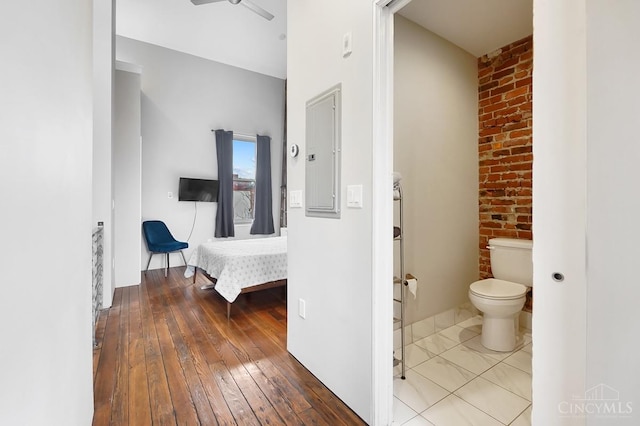 bathroom featuring toilet, hardwood / wood-style floors, and electric panel