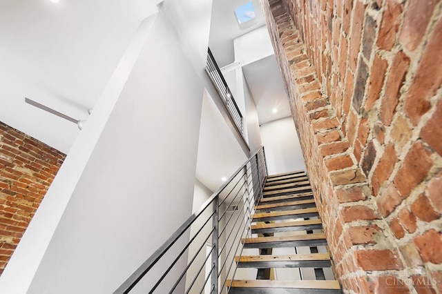 stairs with a high ceiling and brick wall