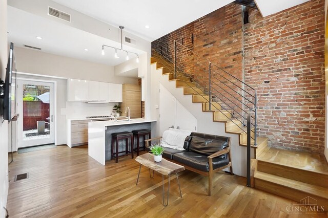 interior space featuring light wood-style flooring, visible vents, and stairs