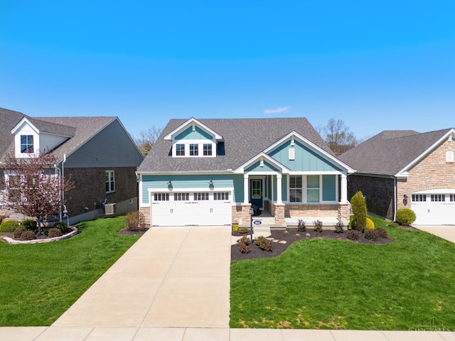 2612 Virgie Ct, Deerfield Twp, OH 45140 - craftsman-style home with a garage, stone siding, a front yard, and concrete driveway
